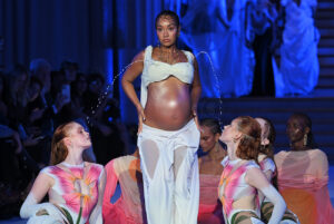 I AM WOMAN! Pregnant Singer Leigh-Anne Pinnock Flaunts Belly Bump And Models Bra With Lactating Milk Stream In DI PETSA’s HOLY MILK London Fashion Week Show